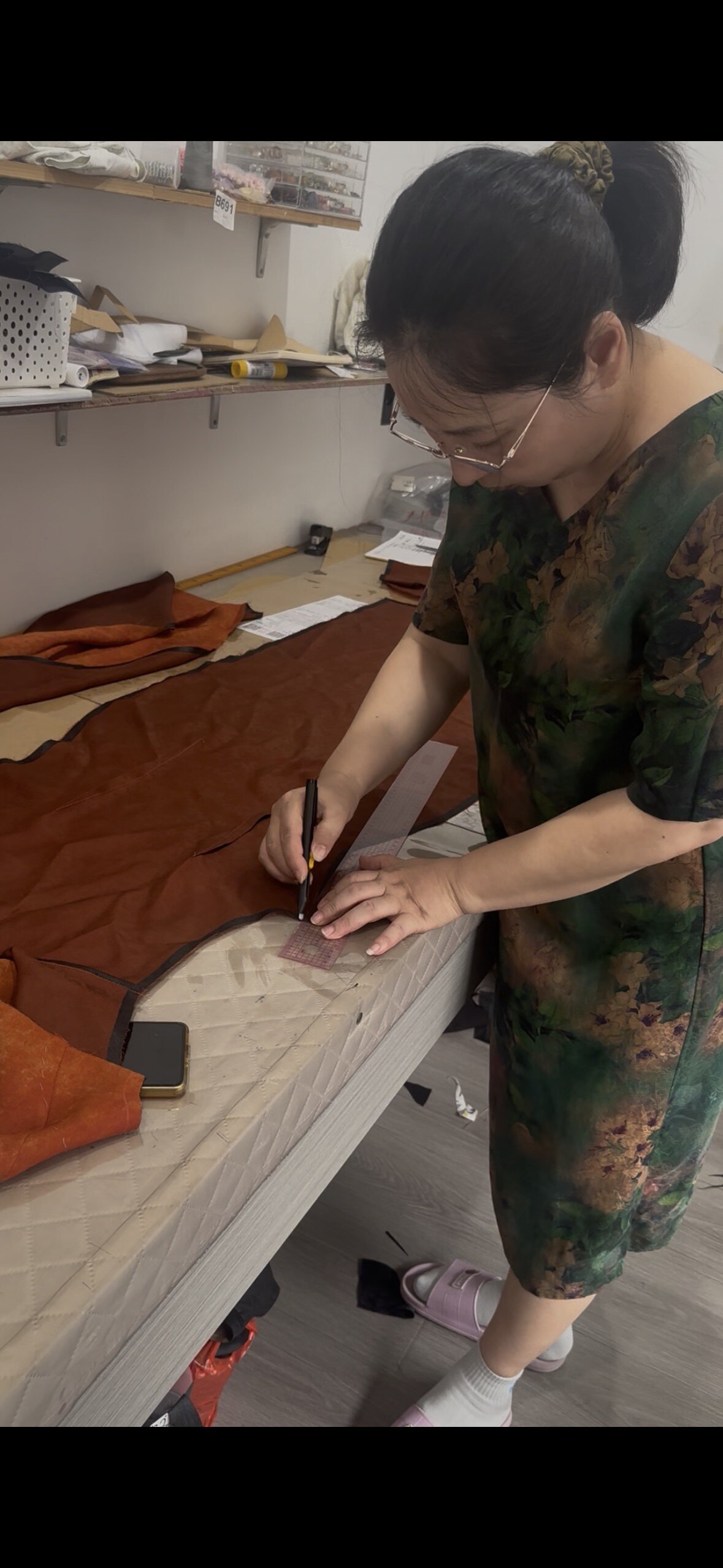 主理人李卫平在工作台上用直尺画版
